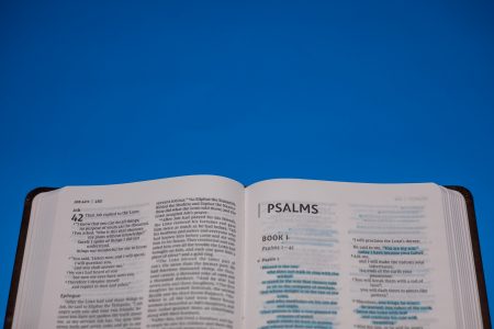 Close up shot of an open bible on a blue surface