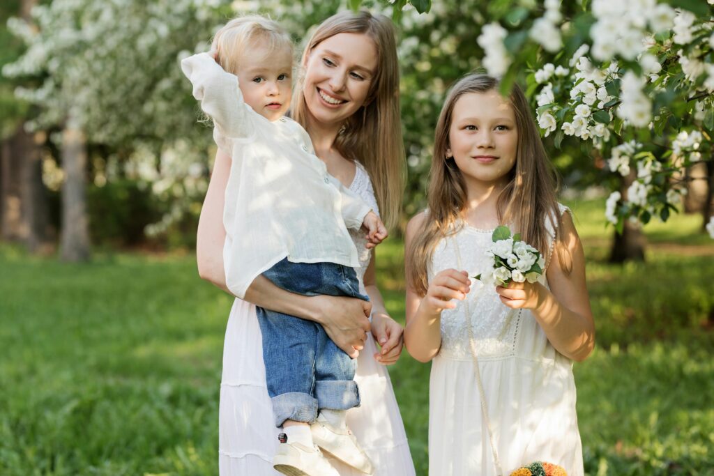 A joyful family moment with mother and children in a blooming park.